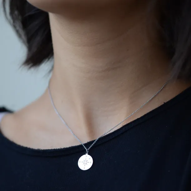 Gold pendant with a compass and a diamond MAP Image