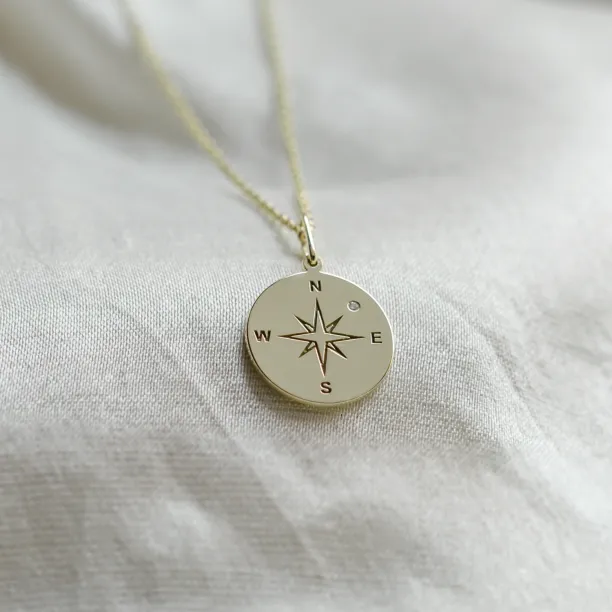 Gold pendant with a compass and a diamond MAP Image