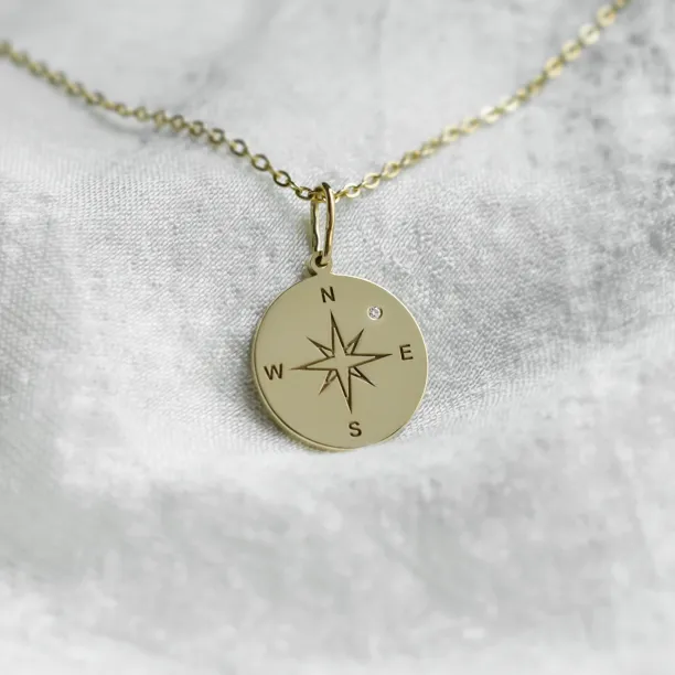 Gold pendant with a compass and a diamond MAP Image